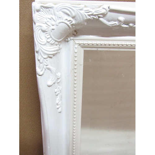 2424 - A wall mirror with painted and moulded framework, the mirror plate with bevelled edge, 120cm x 90cm