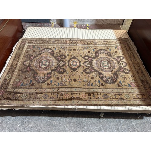 2736 - A Persian rug with two four-pointed central medallions surrounded by a guarded border of branches an... 