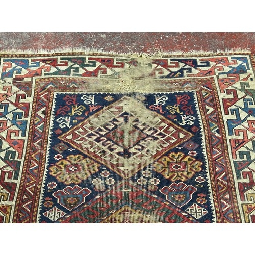 2722 - A Kazak runner with six hooked medallions on a blue ground, 240 cm x 105cm approx. (Worn & torn).