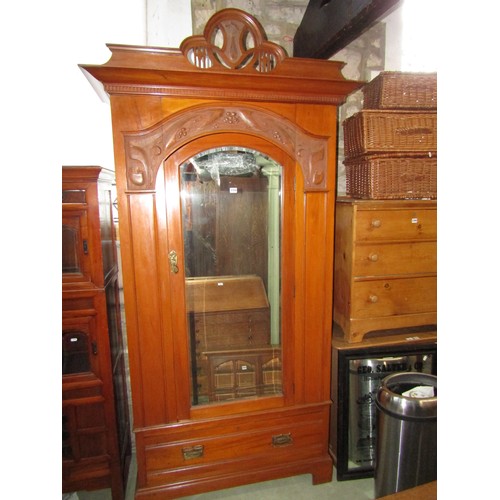 2358 - A good quality art nouveau wardrobe in satin walnut, the arched mirror panelled door beneath a carve... 