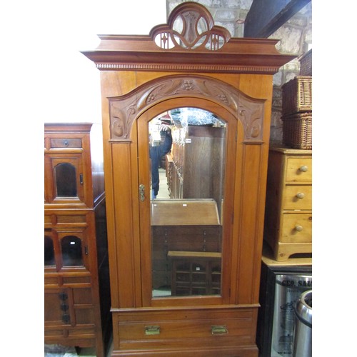 2358 - A good quality art nouveau wardrobe in satin walnut, the arched mirror panelled door beneath a carve... 