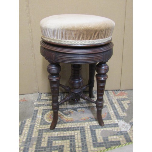 2283 - An Edwardian piano stool the circular upholstered seat raised on turned supports with central column... 