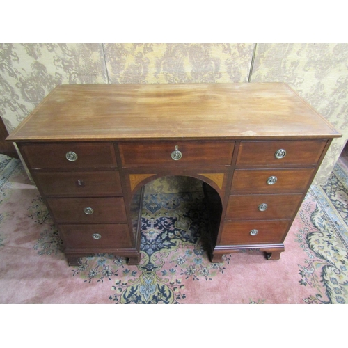 2665 - An Edwardian inlaid mahogany kneehole writing desk of nine drawers, the central arch with further in... 