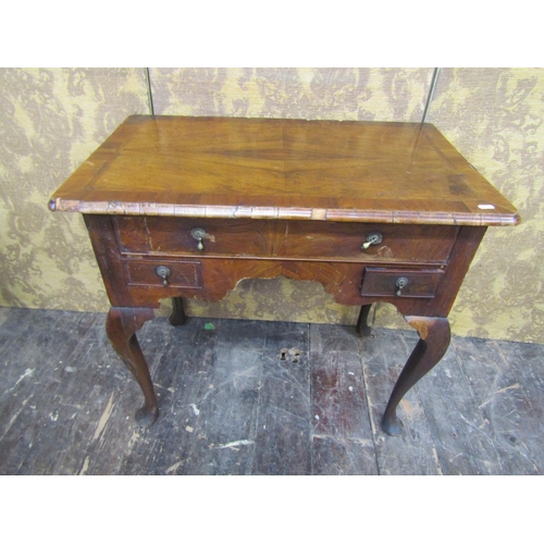 2720 - A Georgian walnut countrymade lowboy fitted with three drawers to a central arch, raised on four pad... 