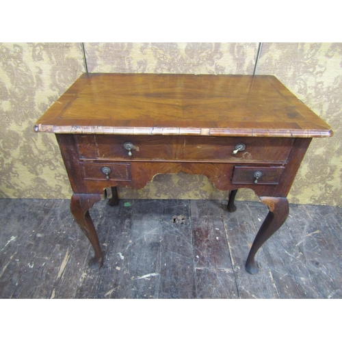 2720 - A Georgian walnut countrymade lowboy fitted with three drawers to a central arch, raised on four pad... 