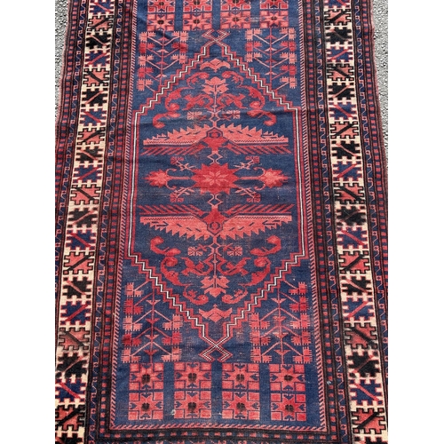 1776 - A Kasack carpet with a central stylised medallion on a red and blue ground, 188cm x 100cm