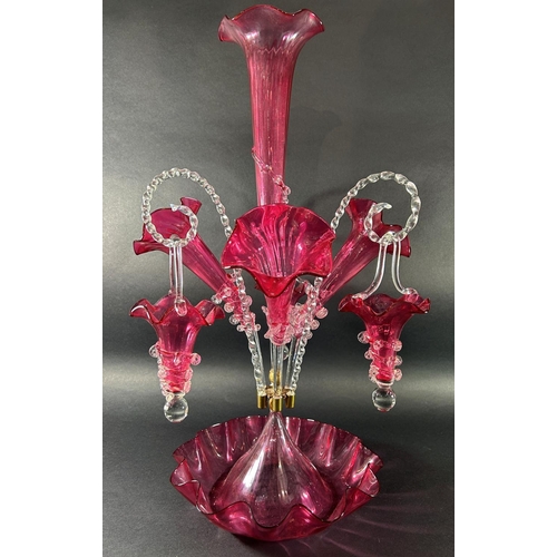 1119 - A 19th century cranberry glass epergne with four trumpets and three clear crook-shaped rope twist ar... 