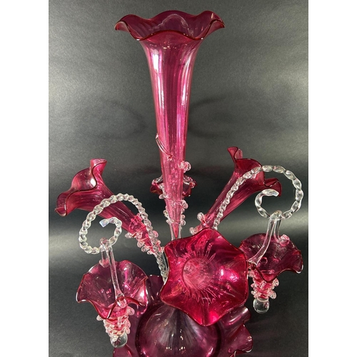 1119 - A 19th century cranberry glass epergne with four trumpets and three clear crook-shaped rope twist ar... 