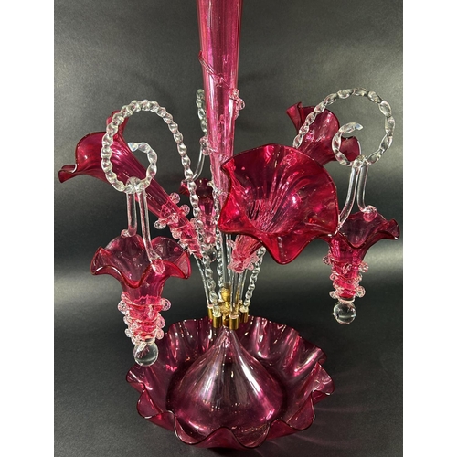 1119 - A 19th century cranberry glass epergne with four trumpets and three clear crook-shaped rope twist ar... 