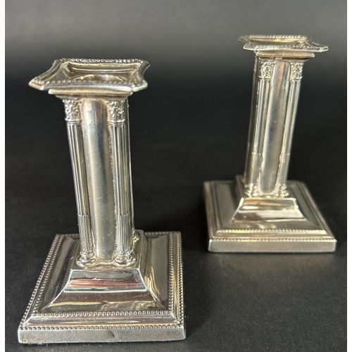 1181 - A pair of small square column candlesticks on a spread base, Sheffield 1904, maker Thomas Bradbury &... 