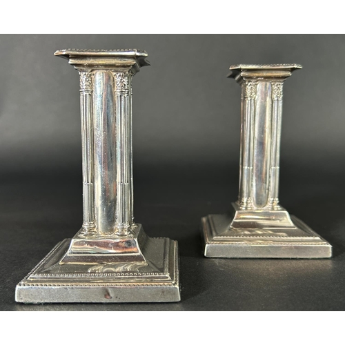 1181 - A pair of small square column candlesticks on a spread base, Sheffield 1904, maker Thomas Bradbury &... 