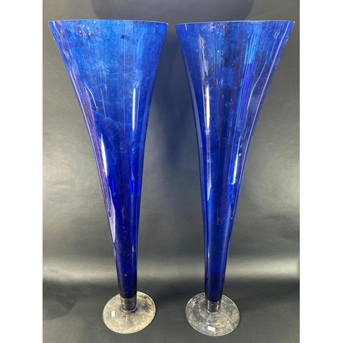 1124 - A pair of large blue flared trumpet vases with a clear circular foot, both standing one metre tall