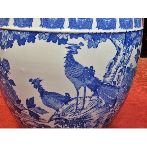 1055 - A large Chinese blue and white porcelain jardiniere / fish bowl decorated with birds amongst foliage... 