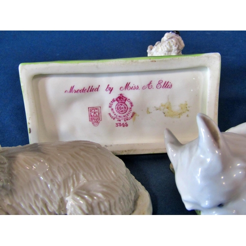 1061 - A group of models of West Highland terriers to include a small Royal Worcester example of a seated W... 