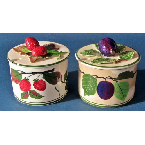 1067 - Two Wemyss type preserve jars and covers with fruit finial lids, together with a Parian ware figure ... 