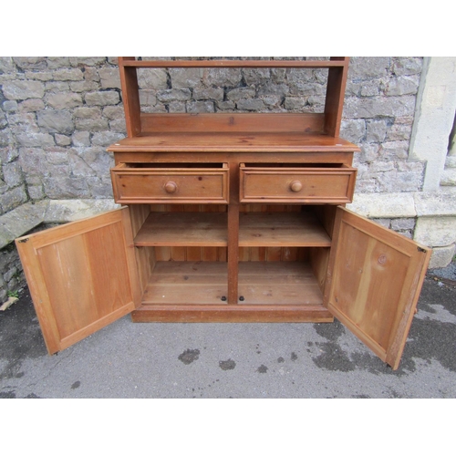 2211 - A small pine kitchen dresser, fitted with two drawers and a pair of panelled doors, below delft rack... 