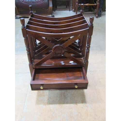 2213 - A mahogany x framed canterbury, with single drawer to base, over turned supports and brass casters, ... 