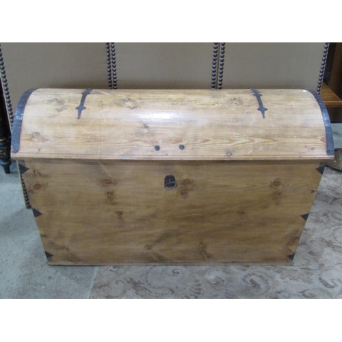 2217 - A large pale pine domed top trunk, with banded hinges over a locking cover (with key) flanked by car... 