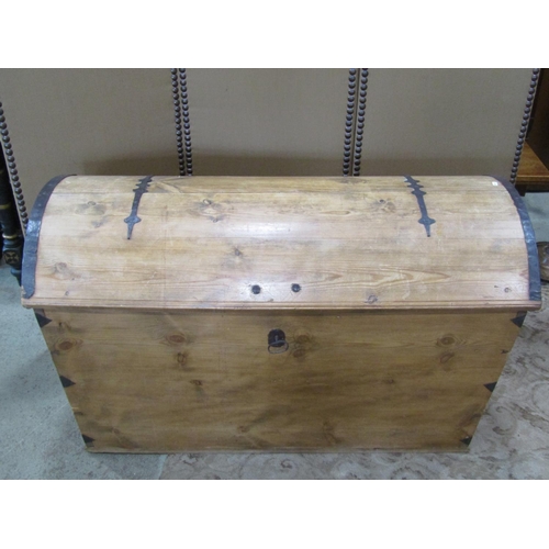 2217 - A large pale pine domed top trunk, with banded hinges over a locking cover (with key) flanked by car... 