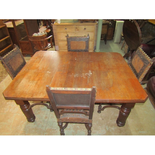 2221 - An Edwardian oak dining table, with canted corners raised on broad fluted supports and casters, 73 c... 