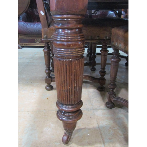 2221 - An Edwardian oak dining table, with canted corners raised on broad fluted supports and casters, 73 c... 