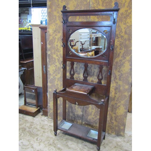 2229 - An early 20th century Arts & Crafts style oak hallstand with pierced detail and enclosing an oval be... 