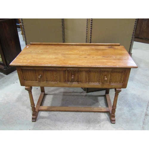 2241 - A small pine side / dressing table, in the Old English / refectory style, fitted with linen fold car... 