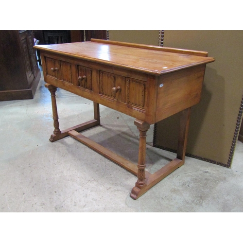 2241 - A small pine side / dressing table, in the Old English / refectory style, fitted with linen fold car... 