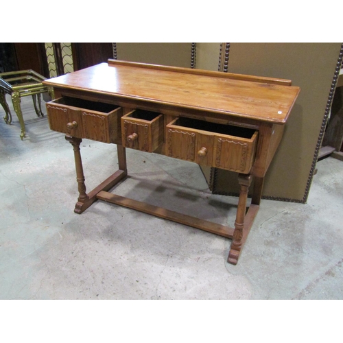 2241 - A small pine side / dressing table, in the Old English / refectory style, fitted with linen fold car... 