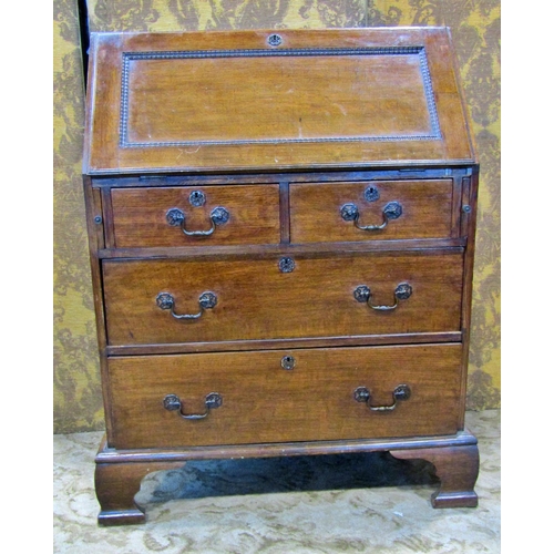 2286 - An Edwardian oak bureau of two long and two short drawers, the fall flap enclosing a fitted interior... 