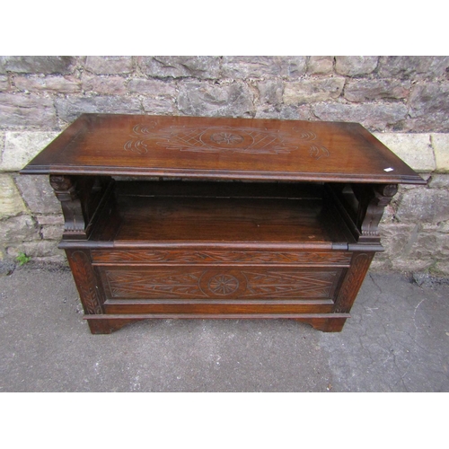 2288 - An Edwardian oak monks bench, with shallow carved detail and arms in the form of lions.