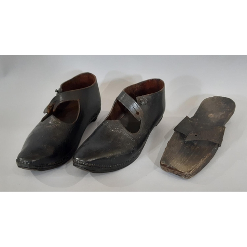 1756 - A pair of late 19th / early 20th century British clogs comprising a black leather upper over a woode... 