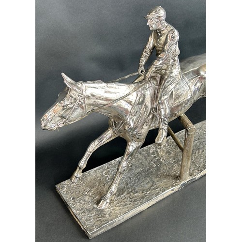 1160 - A large 20th century silver plated statuette of a race horse and jockey clearing a pole fence, tarni... 