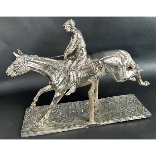 1160 - A large 20th century silver plated statuette of a race horse and jockey clearing a pole fence, tarni... 