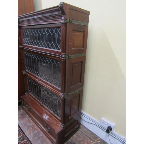 2746 - A four tier globe Wernicke mahogany sectional bookcase. The three leaded light doors over a single d... 