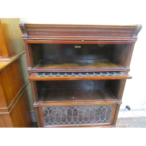 2746 - A four tier globe Wernicke mahogany sectional bookcase. The three leaded light doors over a single d... 