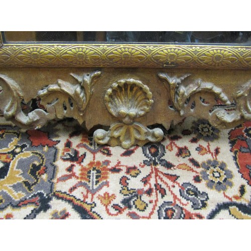 2744 - An antique gilded pier glass, with shaped outline and floral scrolling detail, 110cm high x 55cm wid... 