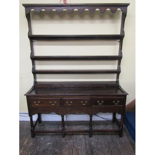 2738 - A small oak cottage dresser the base enclosed with three frieze drawers raised on turned supports, u... 