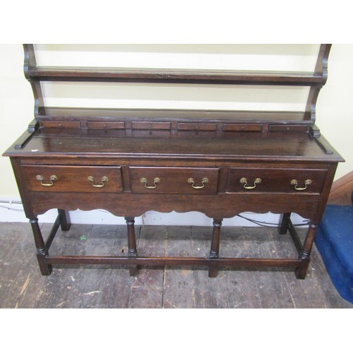 2738 - A small oak cottage dresser the base enclosed with three frieze drawers raised on turned supports, u... 