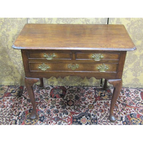 2714 - A Georgian mahogany low boy fitted with three drawers with shaped apron and raised on four pad feet,... 