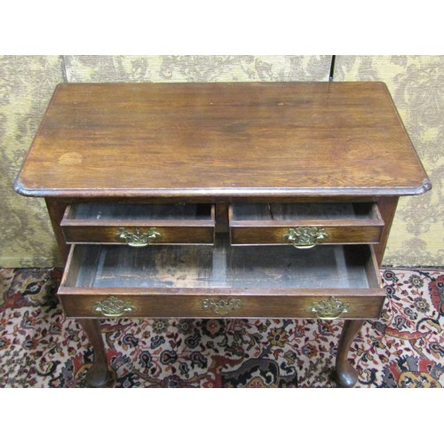 2714 - A Georgian mahogany low boy fitted with three drawers with shaped apron and raised on four pad feet,... 