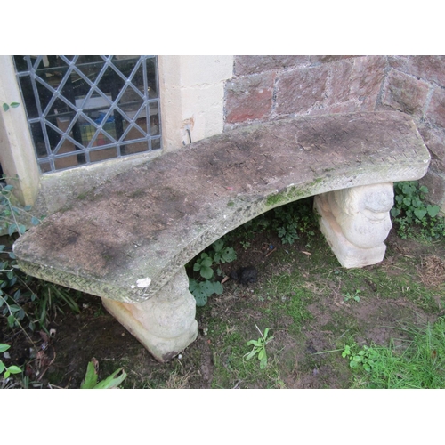 2091 - A weathered cast composition stone three sectional garden bench with curved slab seat raised on wing... 