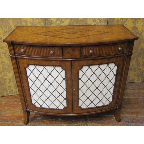 2660 - A reproduction walnut bow-fronted cabinet, the front elevation enclosed by two doors with brass gril... 