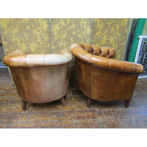 2650 - A pair of buttoned tan leather upholstered tub chairs, with brass stud detail, raised on square tape... 