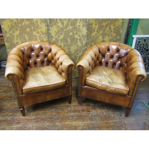 2650 - A pair of buttoned tan leather upholstered tub chairs, with brass stud detail, raised on square tape... 