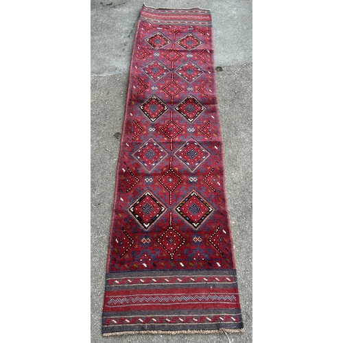 1771 - A Meshwani runner with intermittent diamonds in red and blues,242cm x 57cm