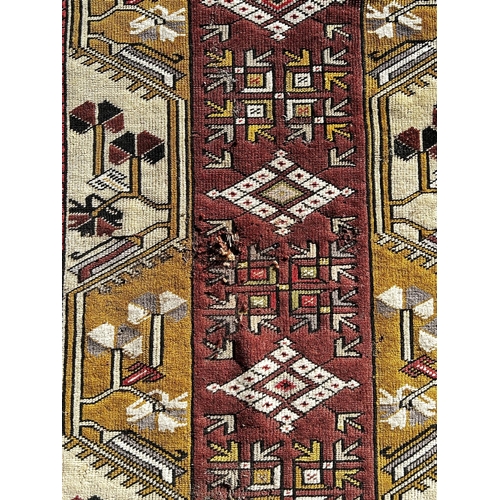 1777 - A Persian rug with a central rectangular panel and stylised flowers, (has two areas of moth holes) 1... 