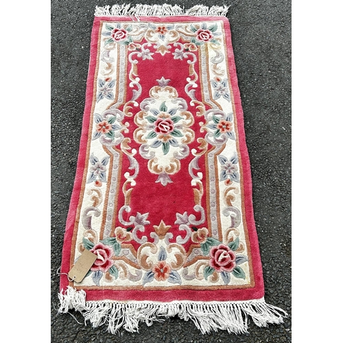 1798 - A pink Chinese deep pile wool carpet with a floral pattern 155 x 77cm approx and a circular Chinese ... 