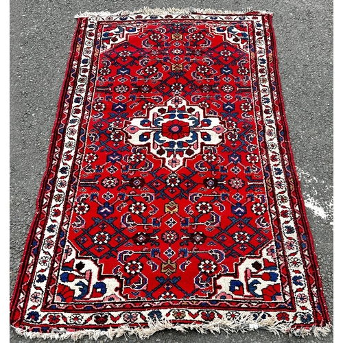 A Bakhtiar type rug with a central founded medallion on a red floral ground