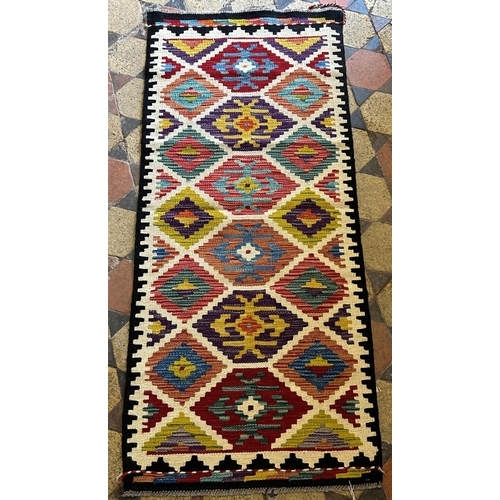 1779 - A Chobi Kilim runner, with repeating stepped medallion between white divisions, 149cm x 66cm approx